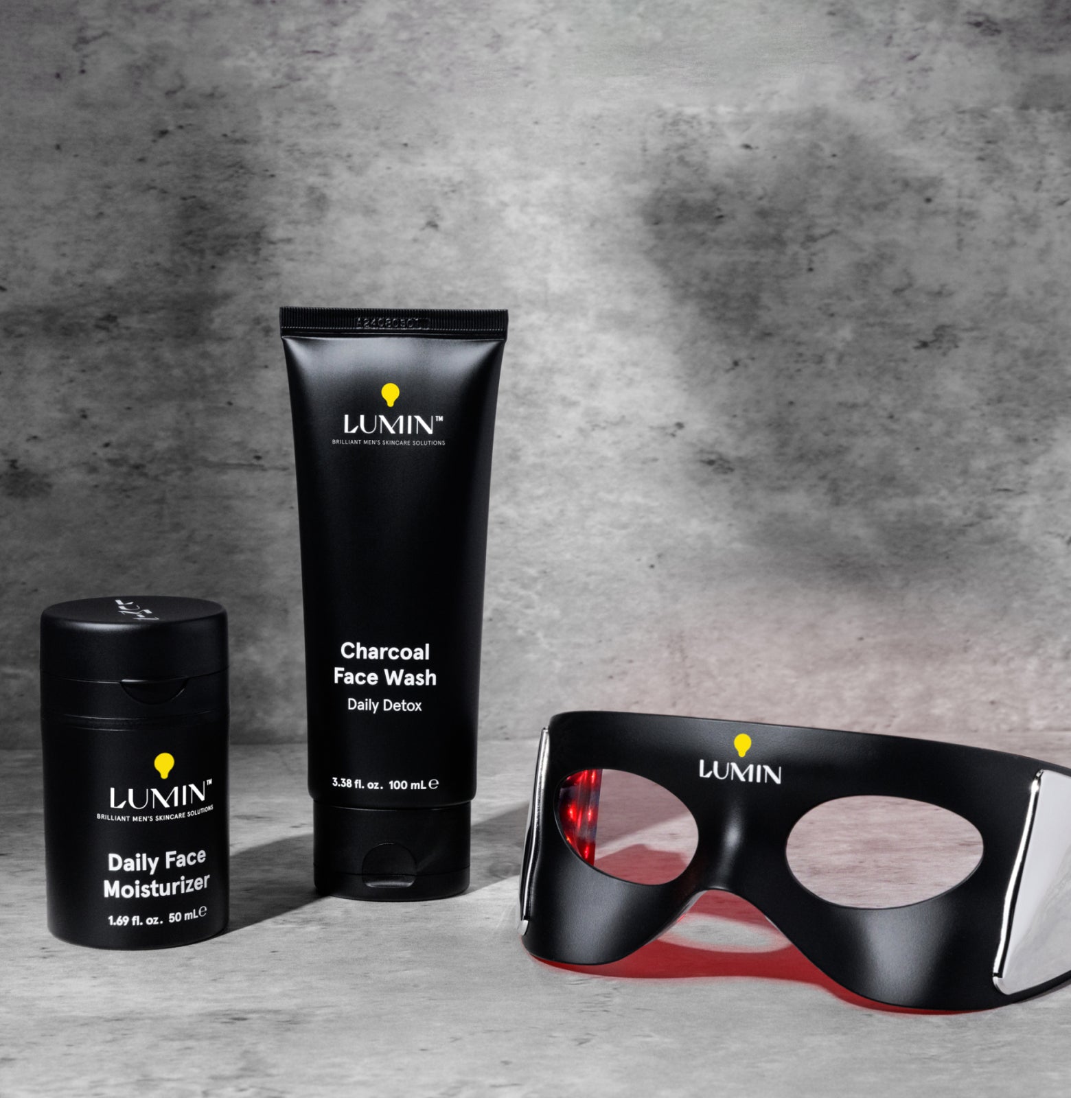 Lumin skincare products including face wash, moisturizer, and mask on a gray background