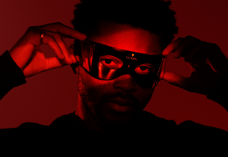 Man adjusting a Lumin skincare LED mask.
