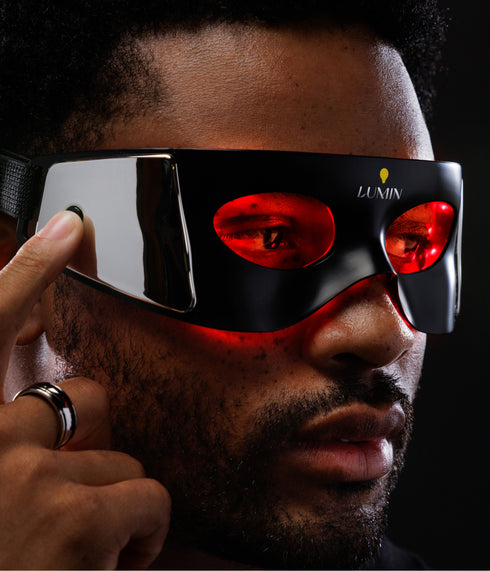 Man wearing sleek black VR headset with red lenses, showcasing immersive virtual reality technology and modern wearable tech.
