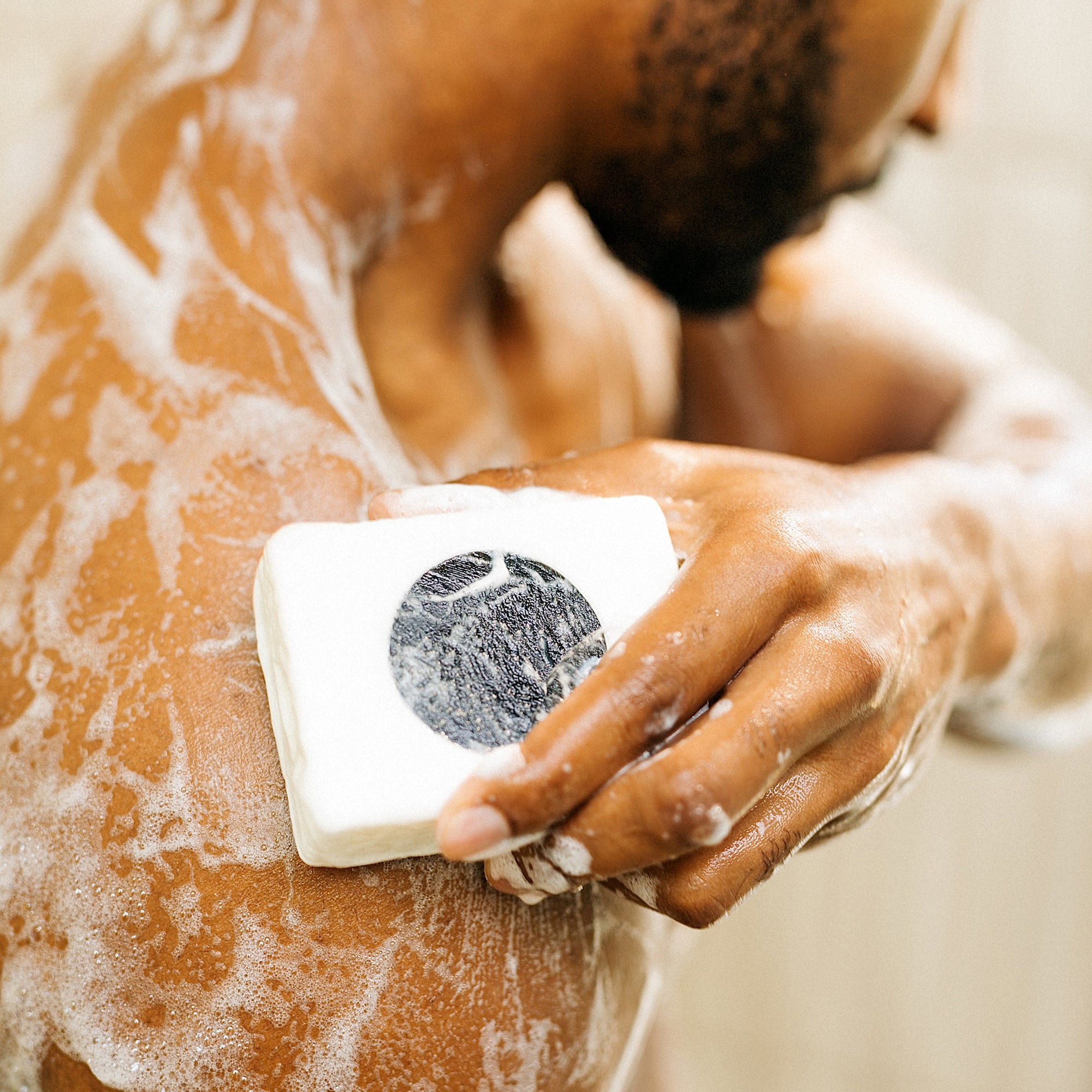 lumin pdp deep cleanse and scrub body bar in use