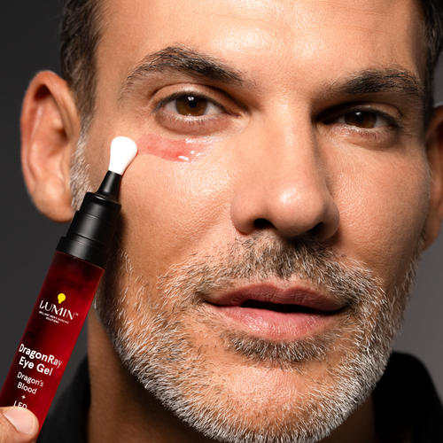 Man applying red under-eye gel cream for dark circles and puffiness, skincare product for men, close-up face care routine