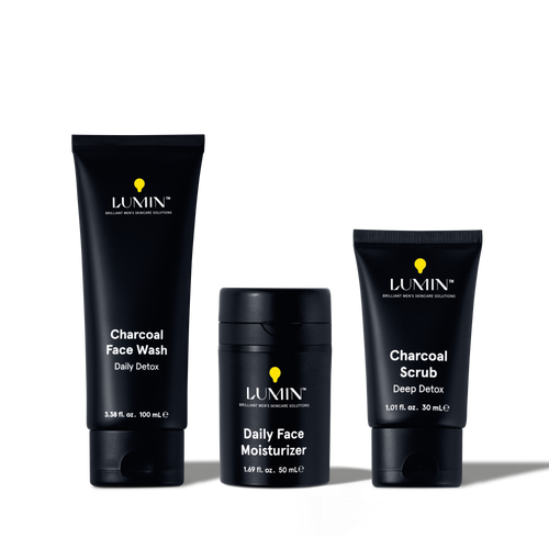 Lumin men's charcoal face wash, daily face moisturizer, and charcoal scrub skincare products in black packaging.