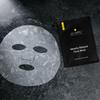 Lumin Weekly Reboot single-use men's sheet face mask with cutouts for eyes, nose, and mouth on textured black surface